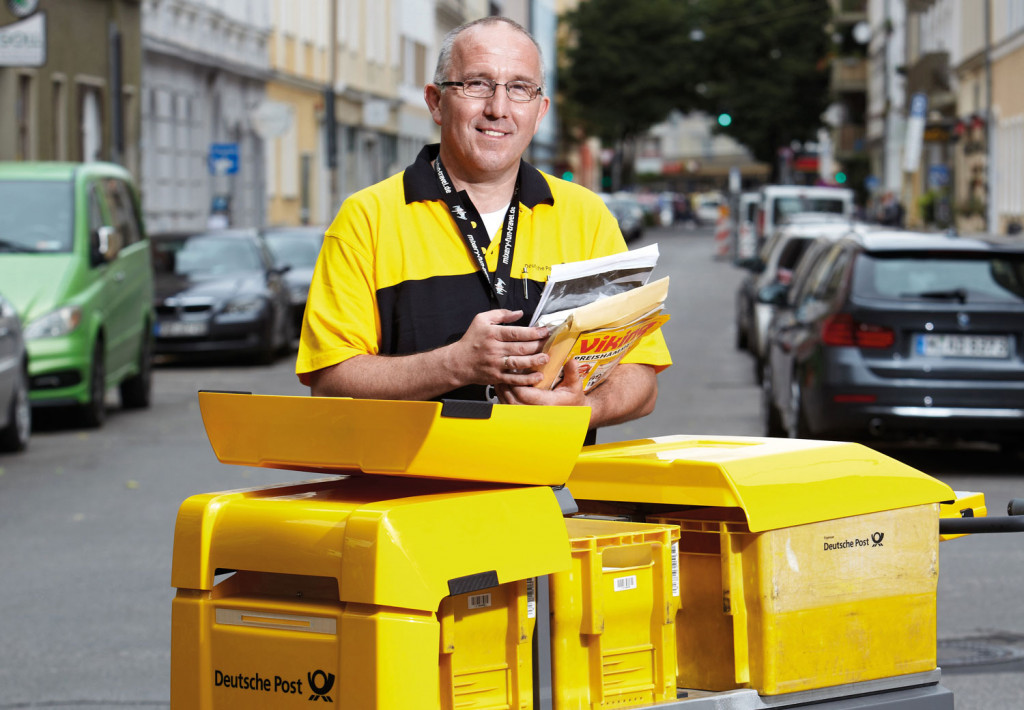 Deutscher Pöstler steht vor dem KYBURZ eTrolley